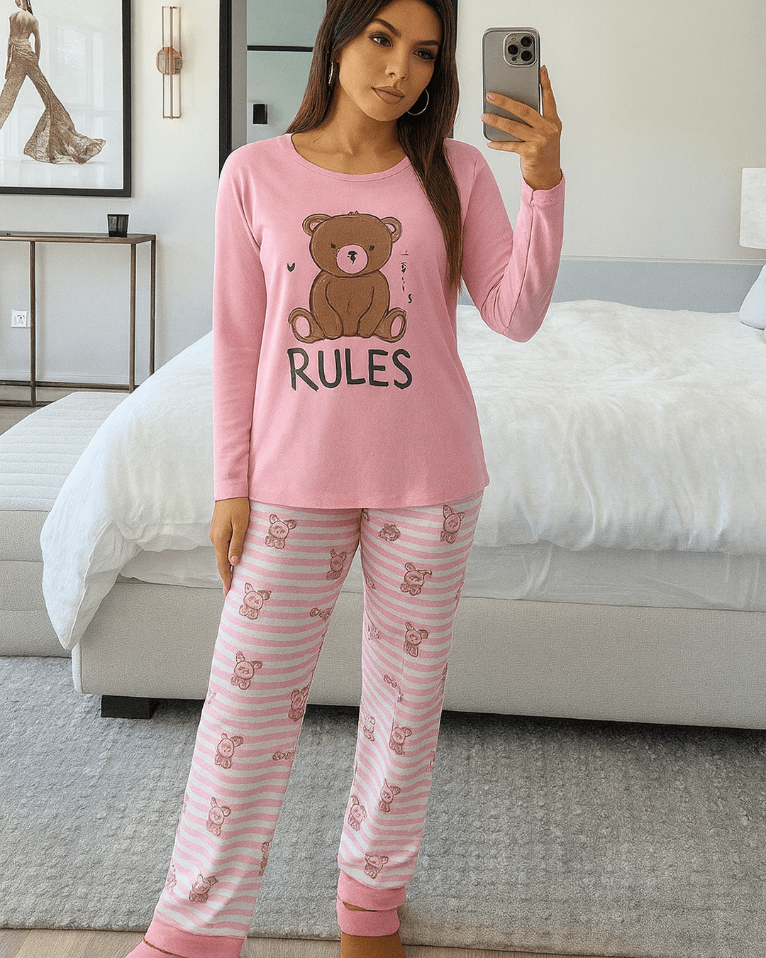 Pink cotton teddy bear pyjama set with long sleeves and striped bear-print pants, cozy winter loungewear for women in a modern bedroom setting.