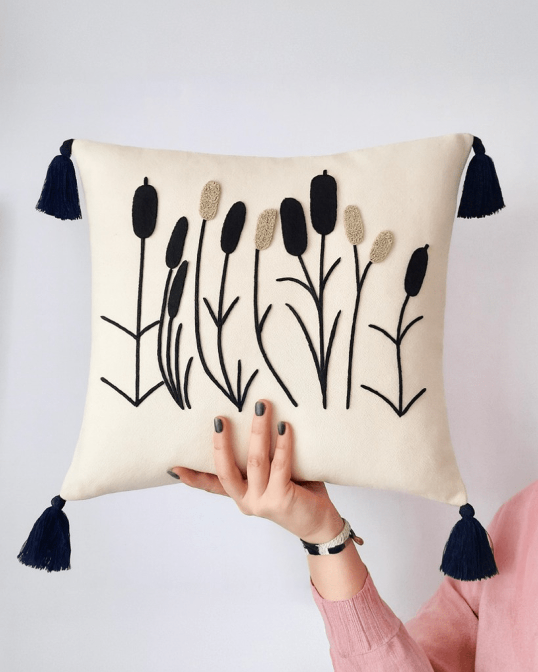 Punch needle decorative cushion with textured tufted design displayed on a modern sofa, neutral cozy home interior styling.